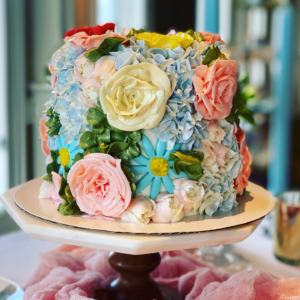 Cake with frosting flowers in pink, yellow, and pink