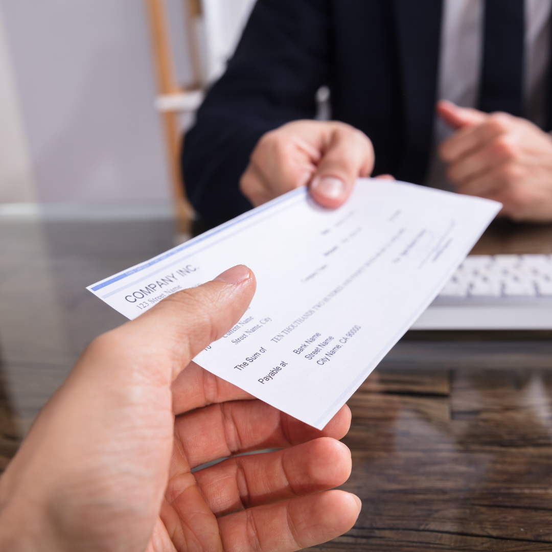 handing over a payroll check